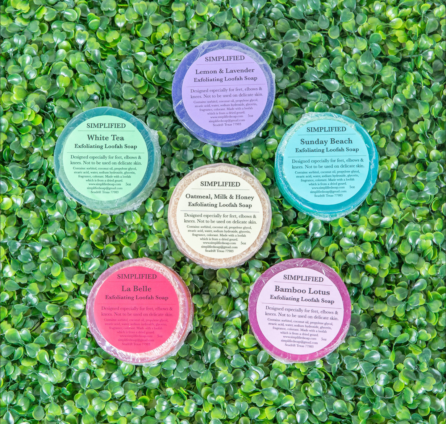 Set of six loofah soaps with labels on a green textured background