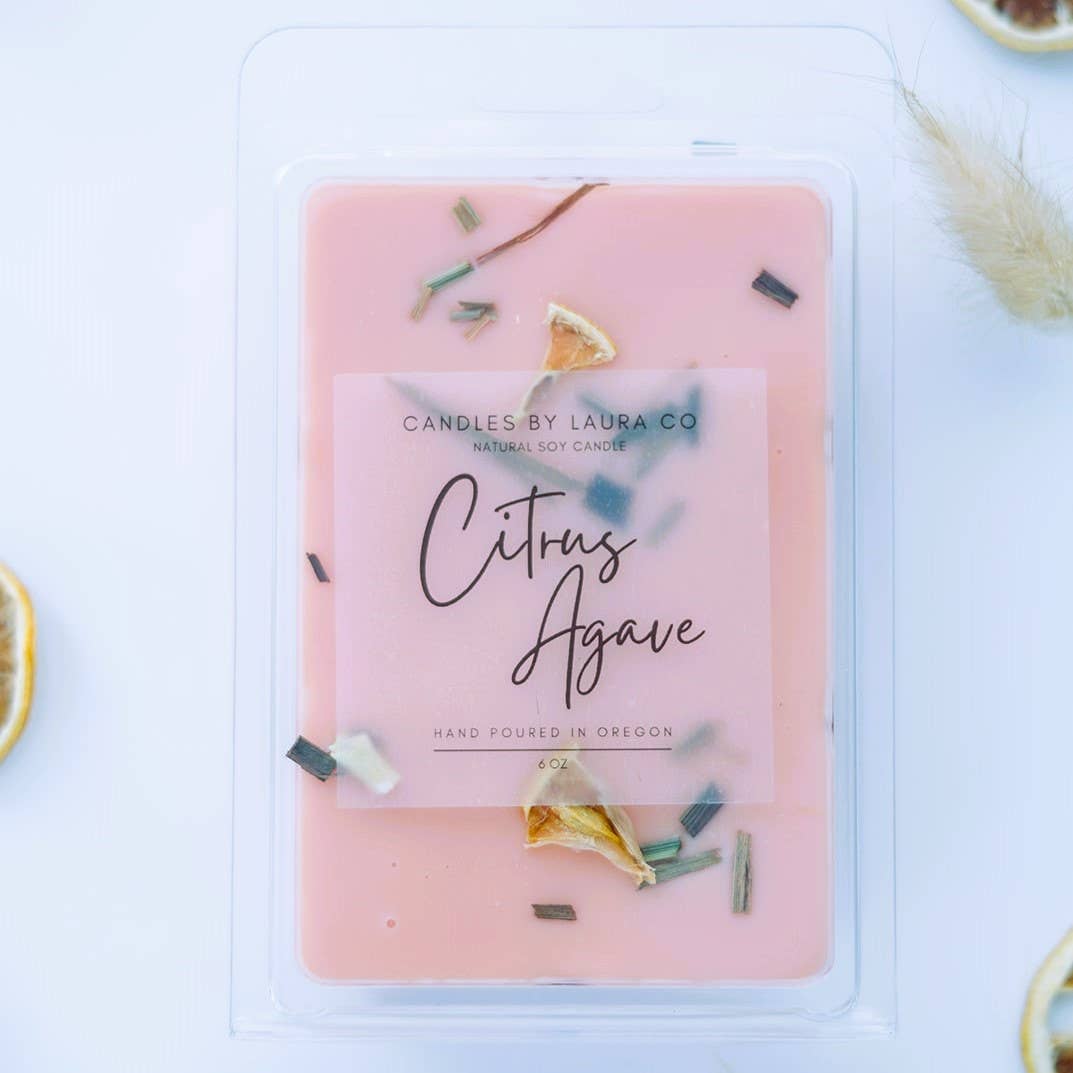 Image of the Citrus Agave wax melt, a pink wax with pieces of lemongrass and fried citrus fruit decorating it.