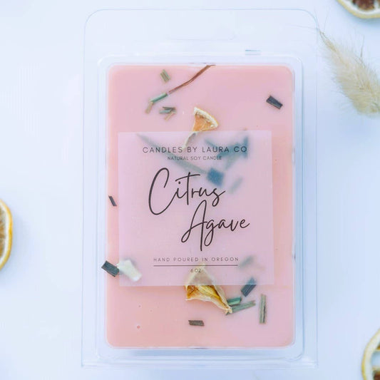 Image of the Citrus Agave wax melt, a pink wax with pieces of lemongrass and fried citrus fruit decorating it.