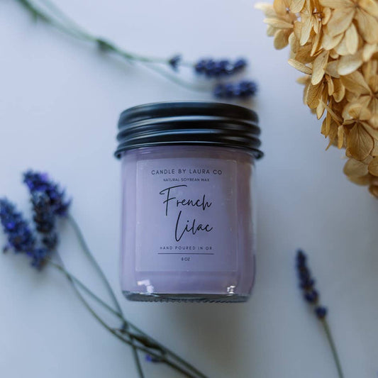 A gentle purple candle in a glass jar, labeled “French Lilac”.