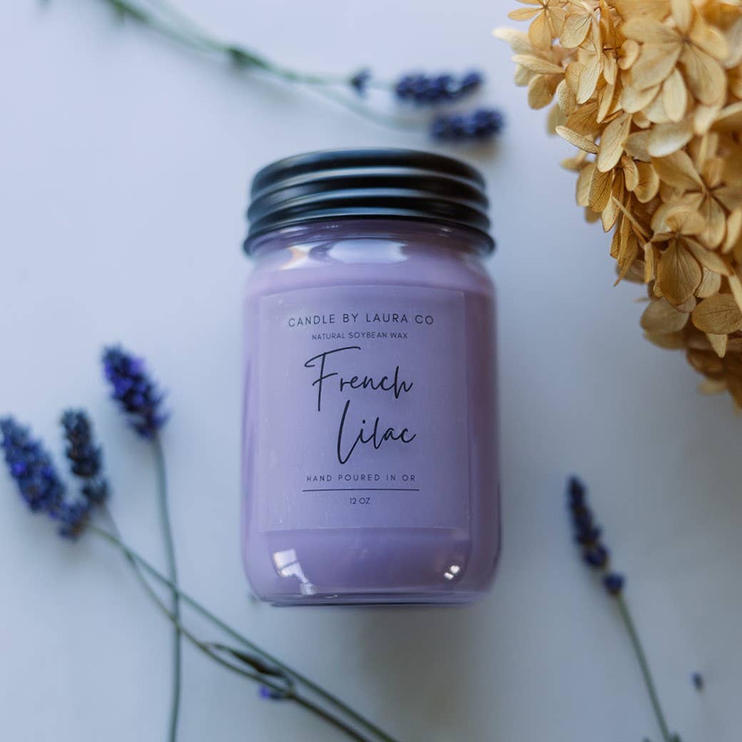 A gentle purple candle in a glass jar, labeled “French Lilac”.