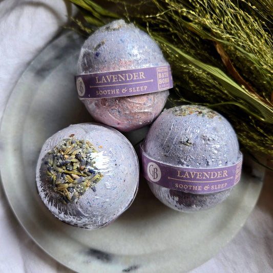 A trio of Lavender bath bombs, purple bath bombs topped with lavender buds.