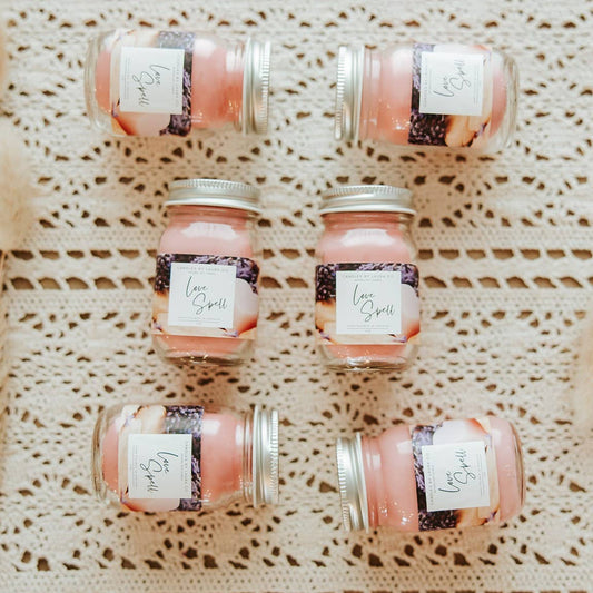 Image of six Love Spell candles, pastel pink candles in miniature mason jars.