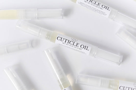 Image depicts several cuticle oil pens scattered across a white background.