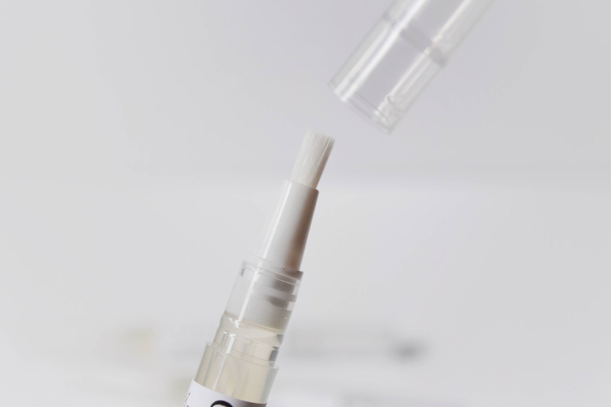 Closeup image of the tip of the oil pen, showing the bristles for brushing onto cuticles.