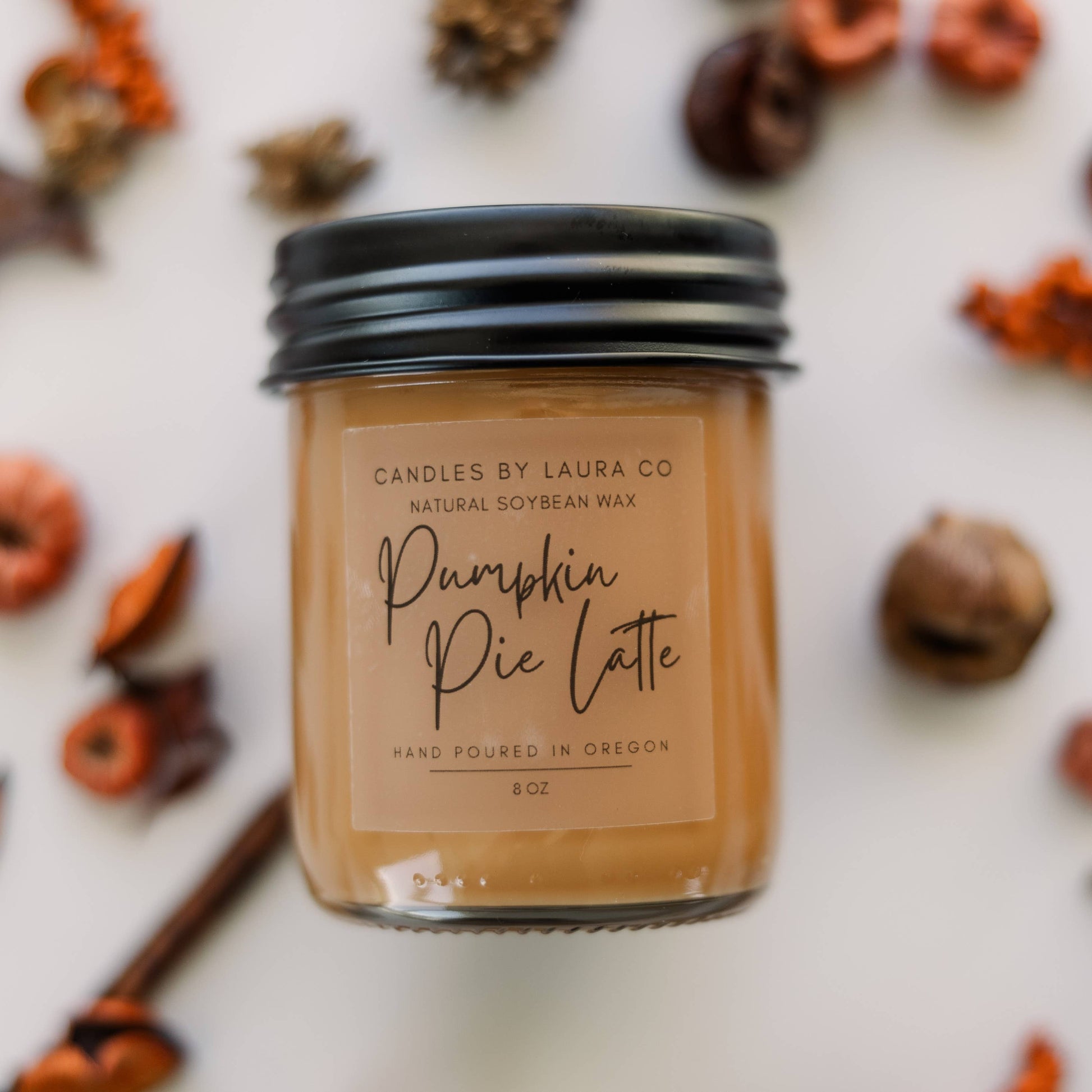Image of the Pumpkin Pie Latte candle, an orange-brown candle in a jar with a black lid.