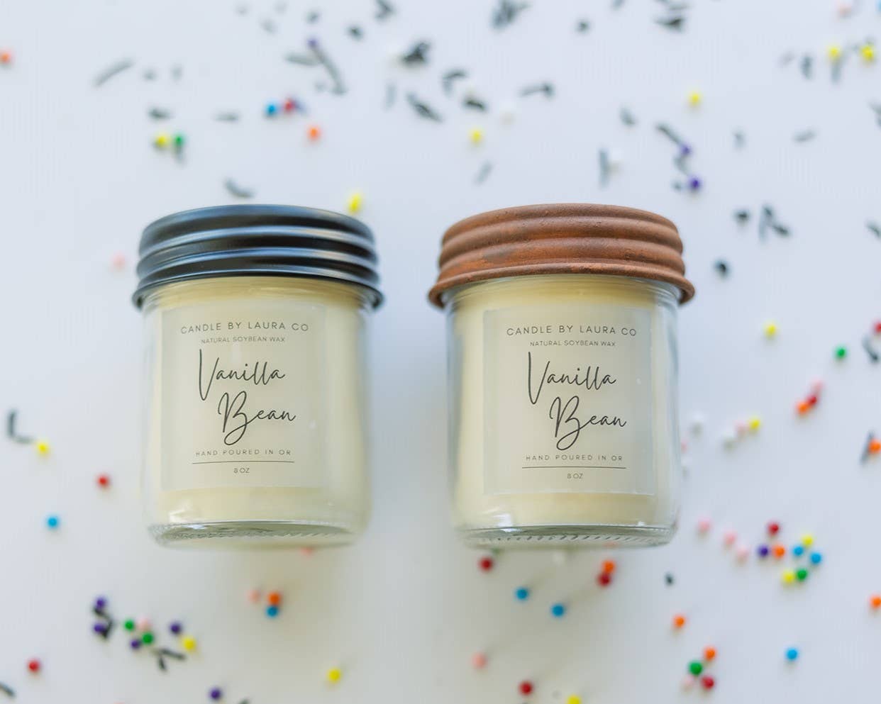 Two off-white candles in glass jars labeled “Vanilla Bean”.