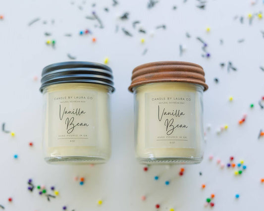Two off-white candles in glass jars labeled “Vanilla Bean”.