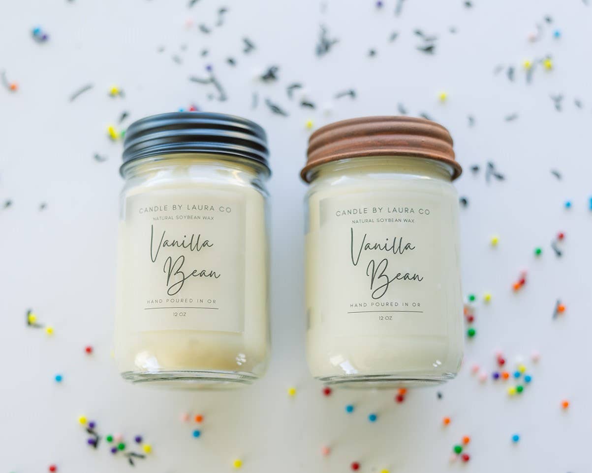 Two off-white candles in glass jars labeled “Vanilla Bean”.