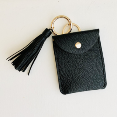 Black leather keychain pouch with tassel on a light gray background