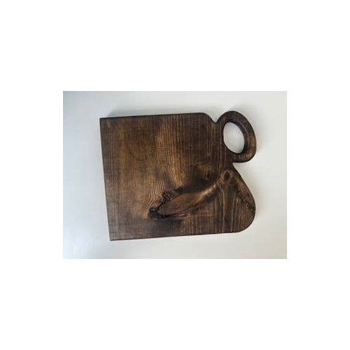A dark brown wooden serving board with a built-in handle and a decorative carved detail, shown on a plain white background.